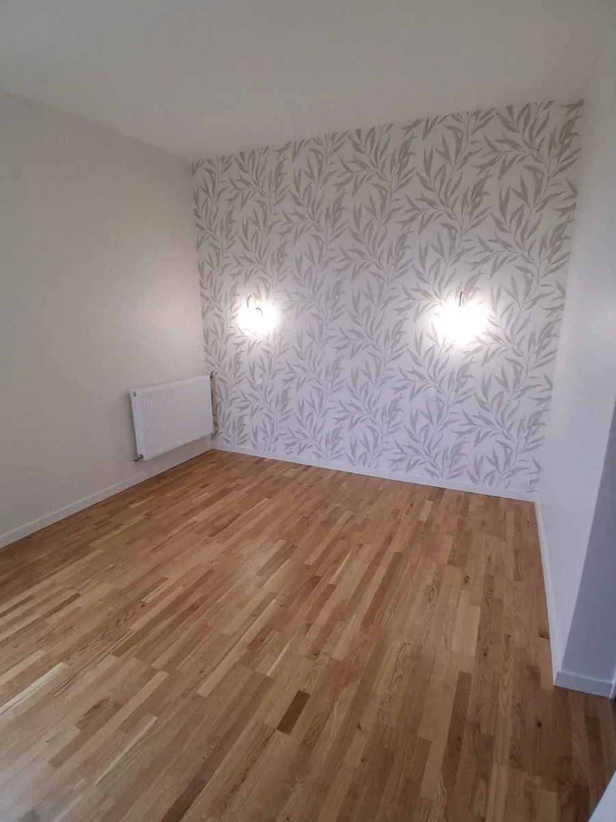 Chambre rénovée avec papier peint feuillage, appliques et parquet chêne, en Essonne