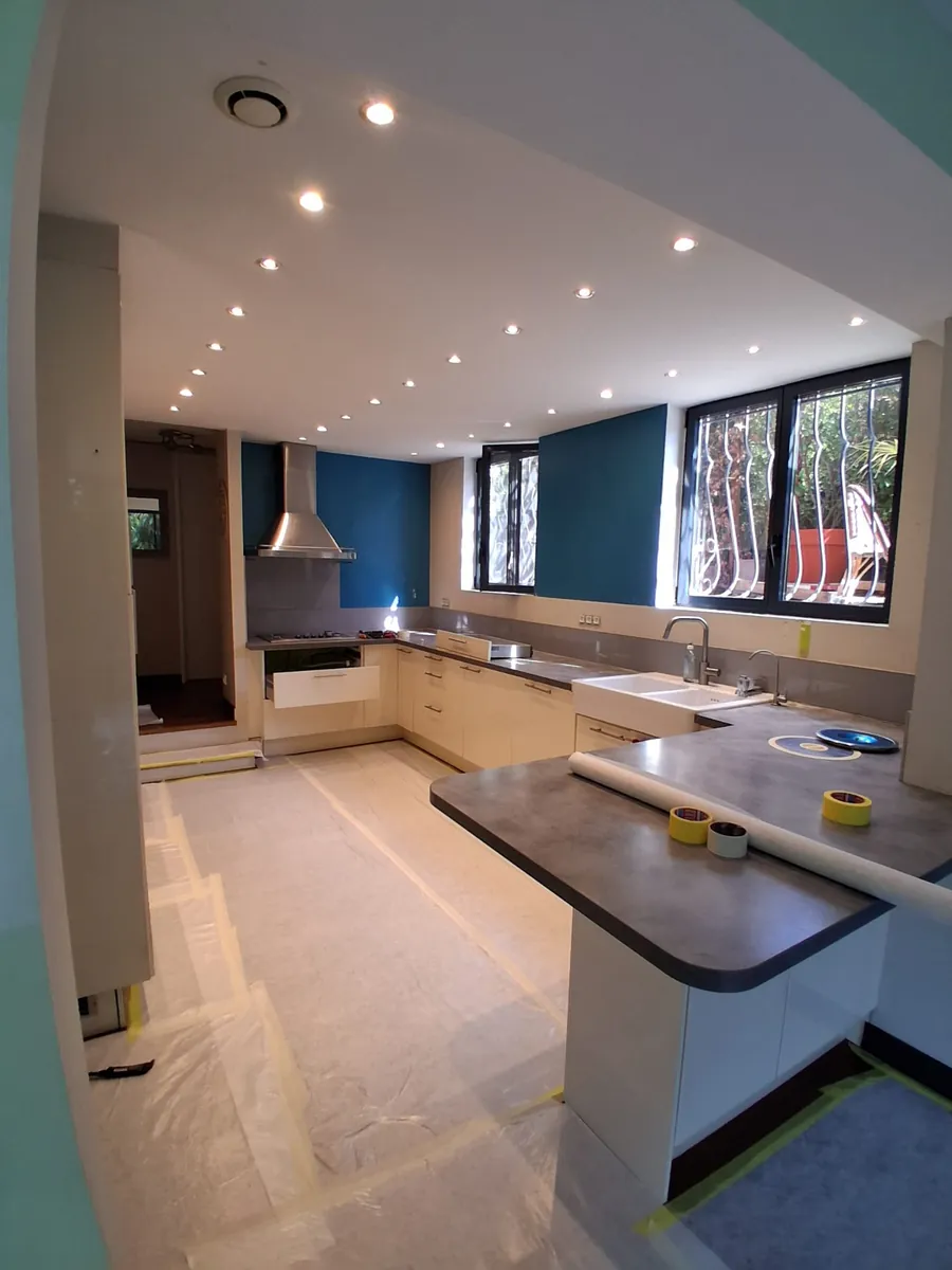 Chantier de rénovation de cuisine avec protections de sol et faux plafond à spots, en Essonne