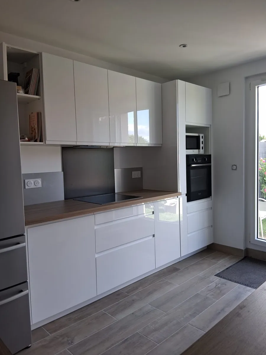 Cuisine blanche laquée équipée avec four encastré et plan de travail bois, en Essonne