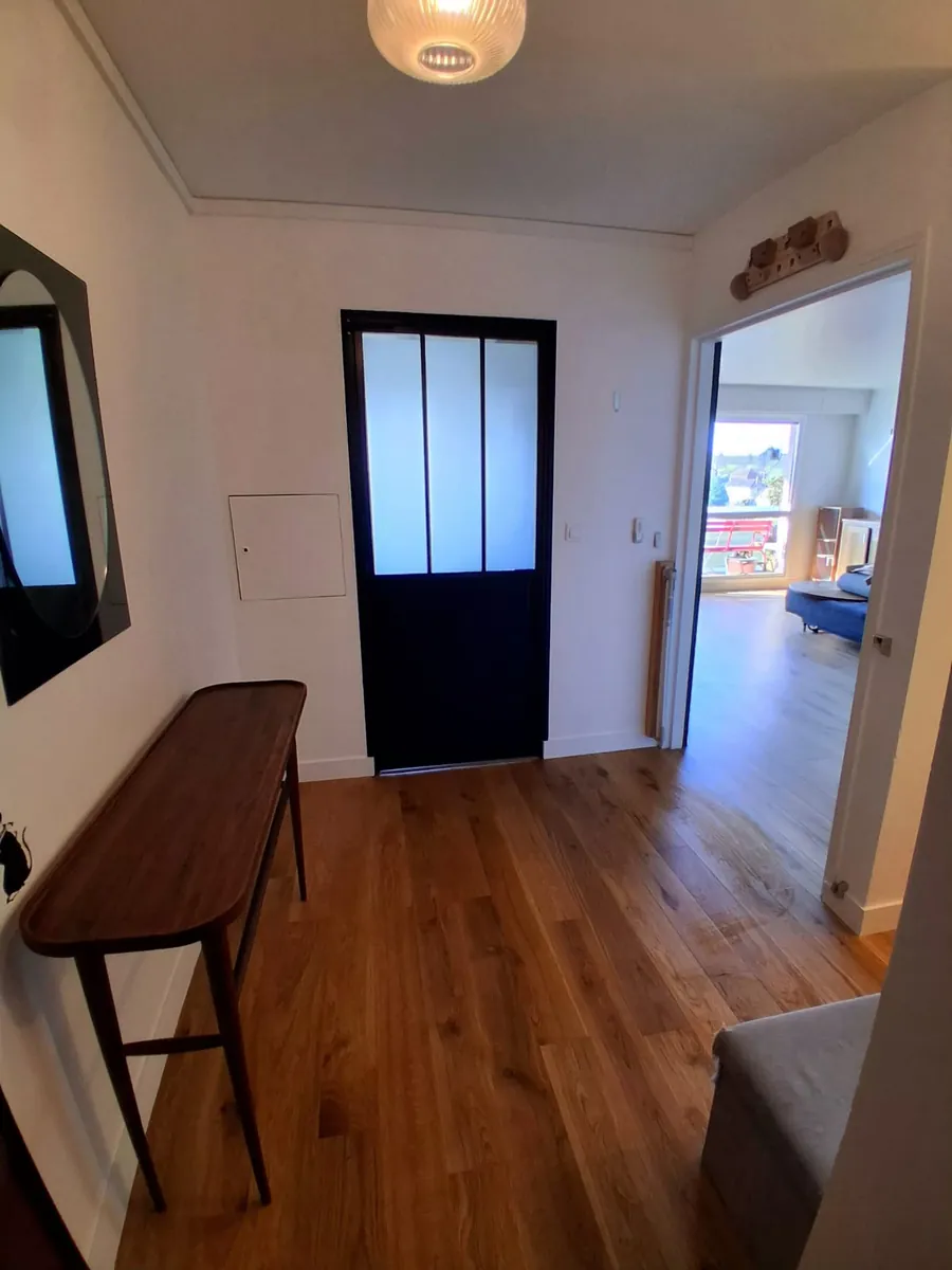 Entrée rénovée avec porte verrière noire et parquet chêne, rénovation intérieure en Essonne