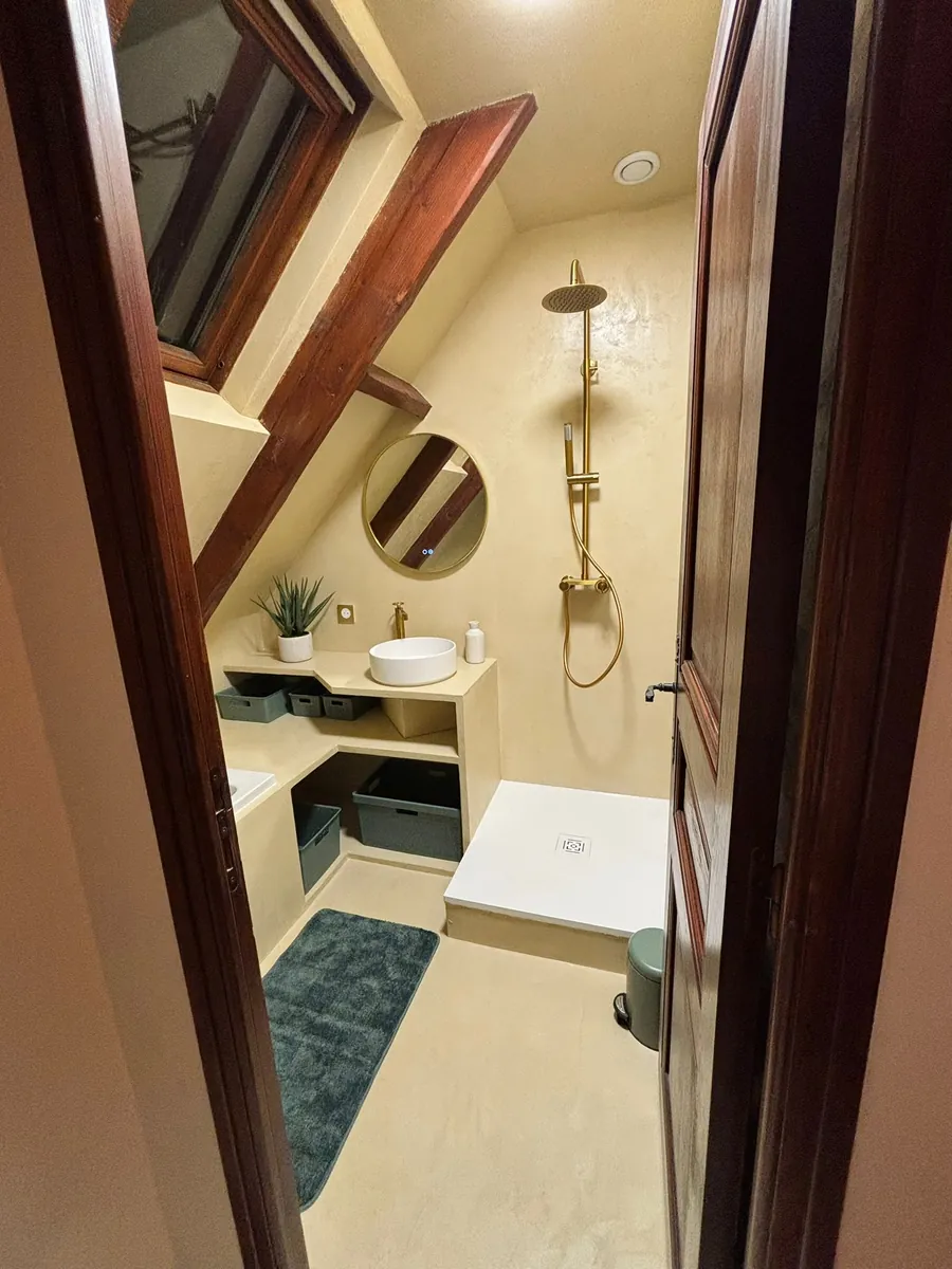 Salle de bain sous combles rénovée en béton ciré avec douche italienne, en Essonne