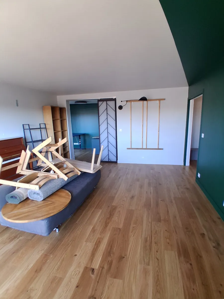 Séjour rénové avec parquet contrecollé chêne et mur vert, réalisation ACOS Renov en Essonne